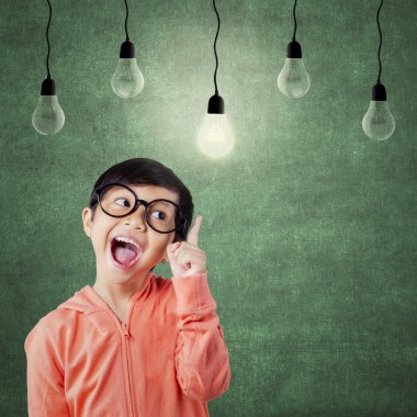 Smart little girl pointing at lamp