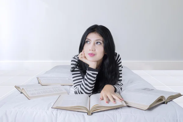 Hübsche Frau mit Büchern auf dem Bett — Stockfoto