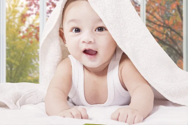 Vrolijke mannelijke kind onder een handdoek — Stockfoto