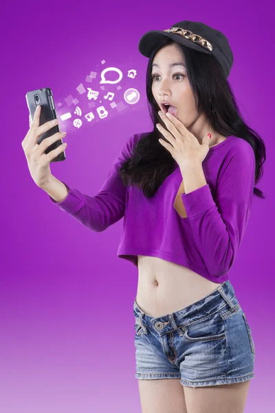 Surprised girl looking message on smartphone — Stok fotoğraf