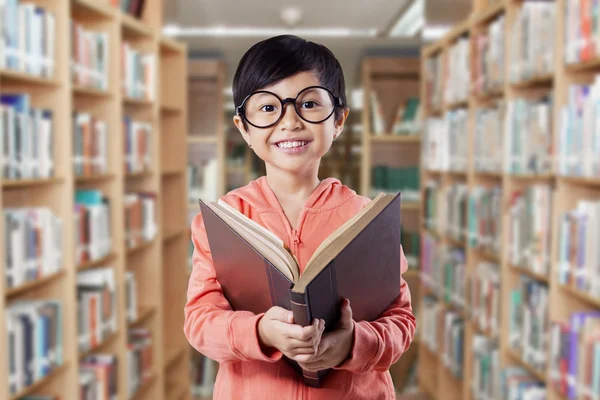 Happy elementary school student reads book — Stockfoto