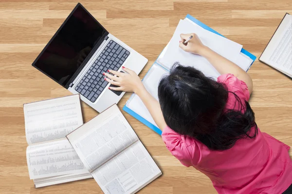 Student studying while lying down on the floor — Stock Photo, Image