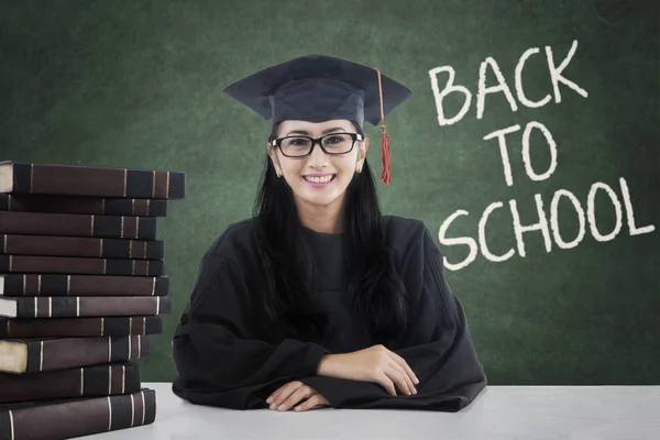 Studente intelligente con vestaglia di laurea torna a scuola — Foto Stock