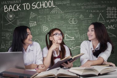 Group of happy students studying in class