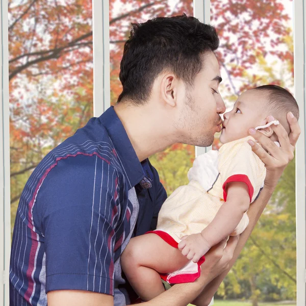 Dad kiss male baby at home — Stok fotoğraf