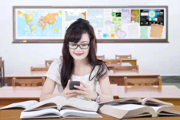 High school learner using smartphone in class — Stockfoto