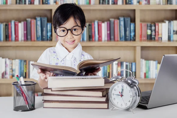 Kindergarten student reading books in library — Stock Photo, Image