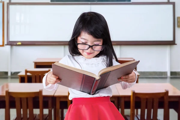 Schöne Grundschülerin liest ein Buch — Stockfoto