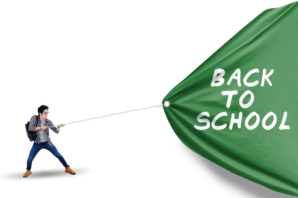 Male student pulling banner of back to school — Stock Photo, Image