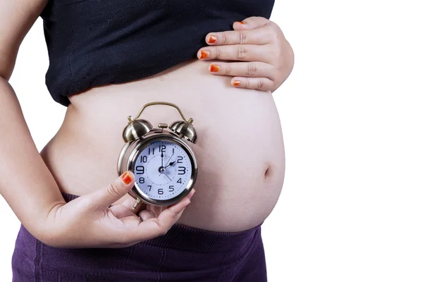 孕妇的肚子和时钟的侧视图 — 图库照片