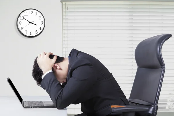 Stressvolle manager op kantoor met klok aan de muur — Stockfoto