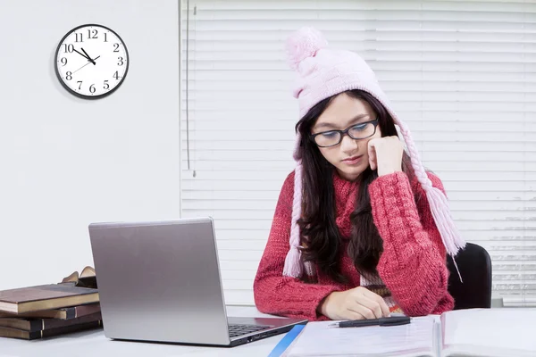 Estudiante estudiando en el escritorio con un reloj en la pared —  Fotos de Stock