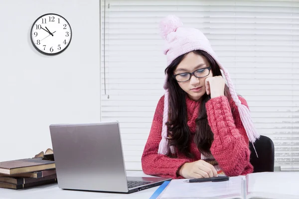 Student lernt am Schreibtisch mit Uhr an der Wand — Stockfoto