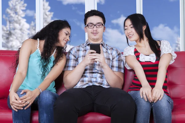 Due ragazze che sbirciano un uomo invia un messaggio — Foto Stock