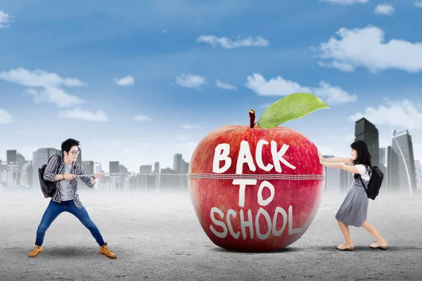 Two learners and apple with text of back to school — Stock Photo, Image