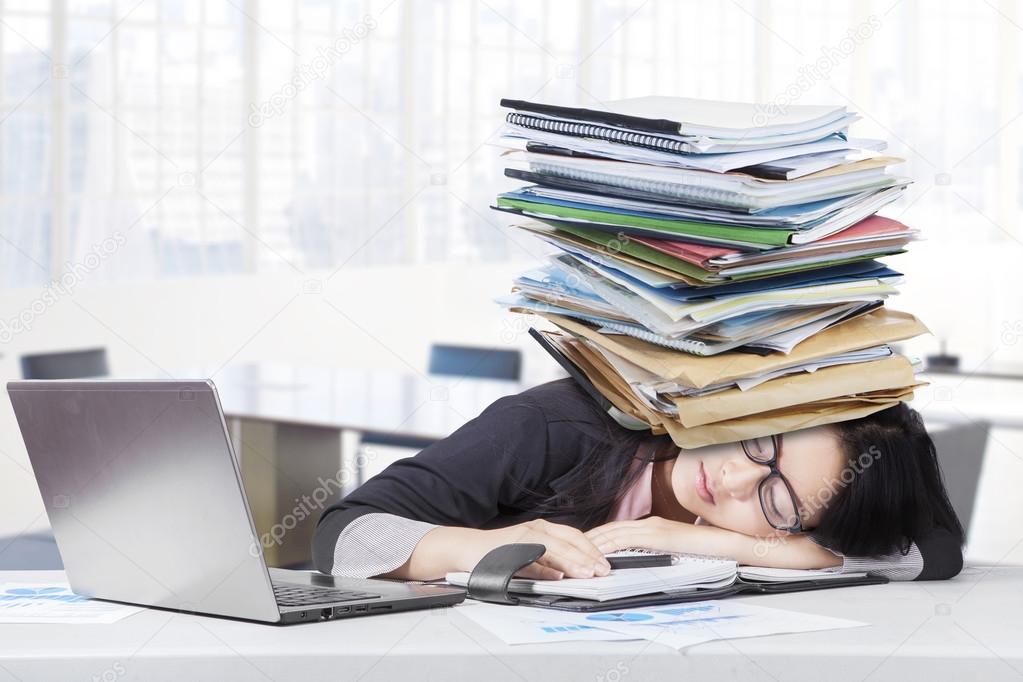 Overworked worker with paperwork on head