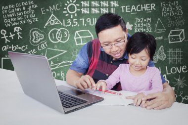 Kız öğrencinin sınıf içinde öğretmen ile eğitim