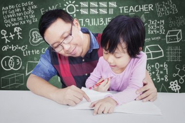 Küçük kız ile erkek öğretmen sınıfında öğrenir