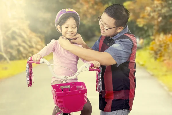 Papà fissare casco su sua figlia testa — Foto Stock