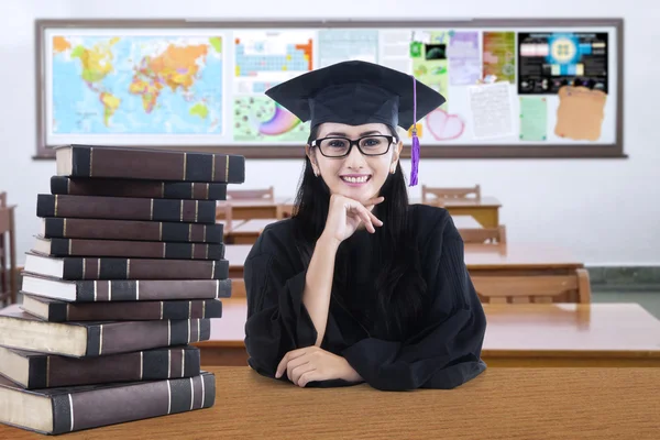 Afgestudeerde student zitten en glimlachend in de klasse — Stockfoto