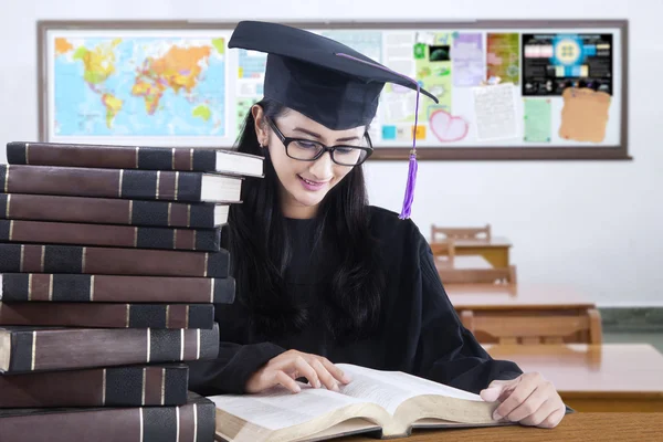 Étudiant diplômé avec des livres de lecture de mortier — Photo