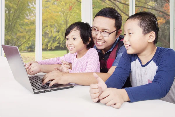 Glada barn spelar laptop med pappa — Stockfoto