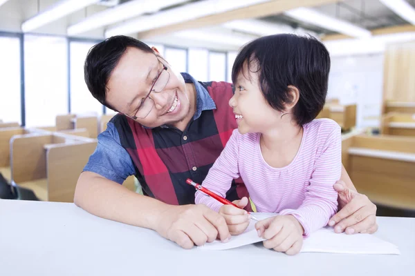 Kleines Mädchen lernt mit männlichem Lehrer in der Klasse — Stockfoto