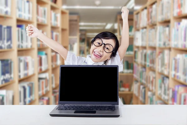 Criança inteligente comemorando sua realização na biblioteca — Fotografia de Stock