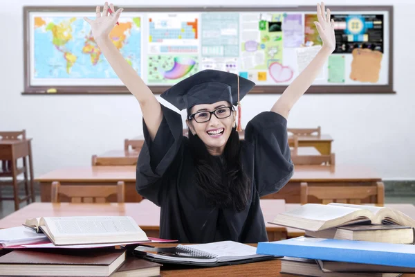 Estudiante exitoso con bata de graduación en clase — Foto de Stock