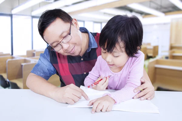 Süßes Mädchen lernt in der Klasse mit dem Lehrer — Stockfoto