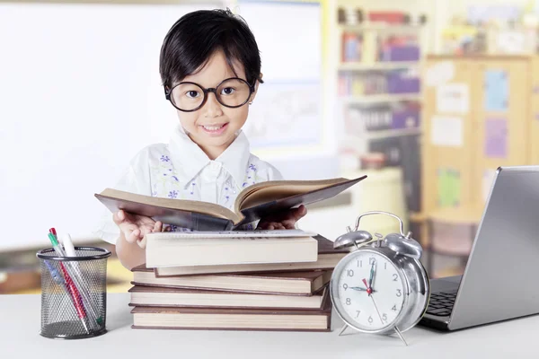 Süße Kindergartenschülerin liest Bücher — Stockfoto