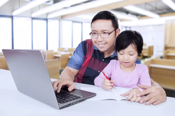 Nachhilfelehrer benutzt Laptop während er seinen Studenten unterrichtet — Stockfoto