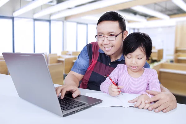 Tutor utilizzando il computer portatile mentre insegna al suo studente — Foto Stock