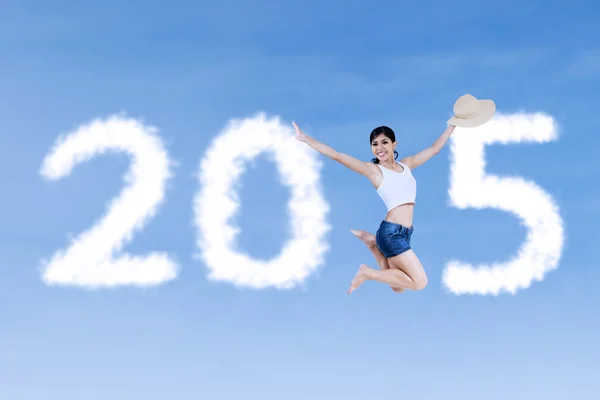 Женщина прыгает и формирует номер 2015 — стоковое фото