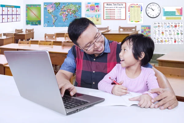 Junge Lehrerin unterrichtet kleinen Schüler in der Klasse — Stockfoto