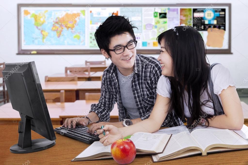 Two students talking and laughing in the class