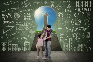 Father and child in front of a key hole