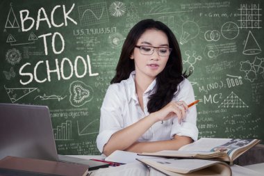 Female high school student learning in class