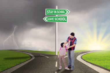 Girl and dad with road sign to stay or leave school