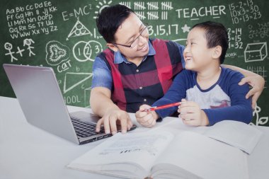 Male student talking with teacher while studying