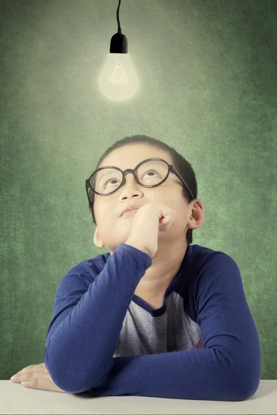 Adorable boy looking at bright light bulb — ストック写真