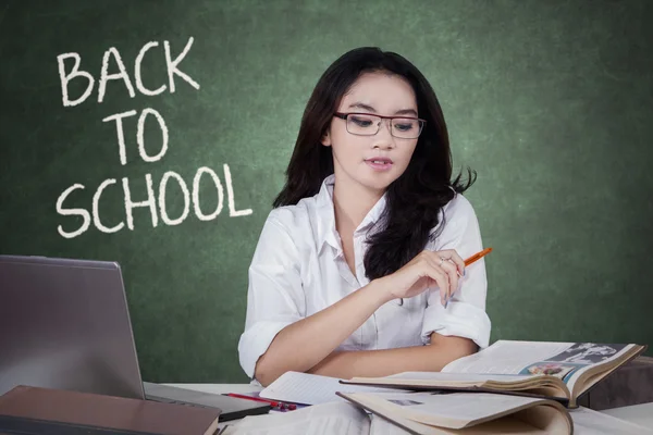 Asiatico adolescente studente lettura libro in classe — Foto Stock