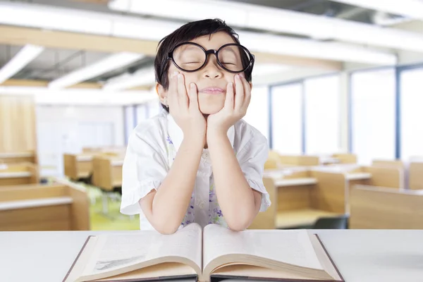 Bela estudante de jardim de infância sonhando acordado em sala de aula — Fotografia de Stock