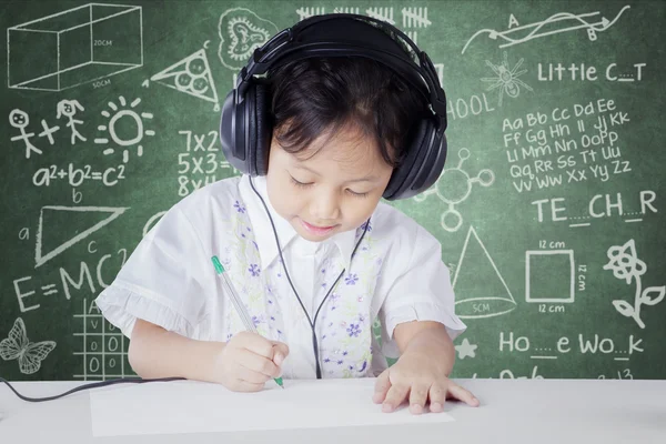 Child learning in class while wearing headphones — Stok fotoğraf