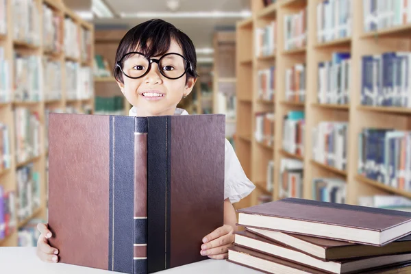 Cute schoolgirl with glasses reading books — Zdjęcie stockowe