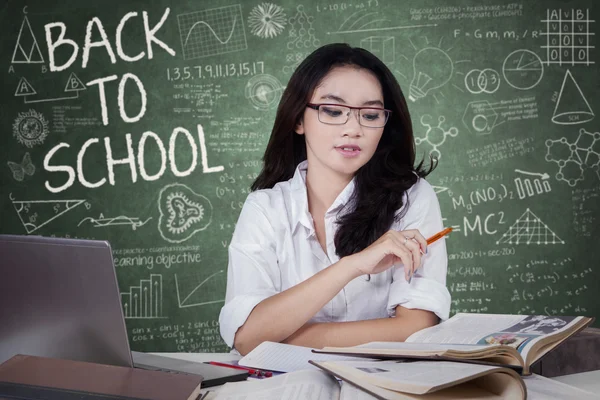 Female high school student learning in class