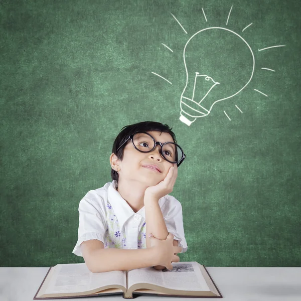 Primary school student imagining a light bulb — Stockfoto