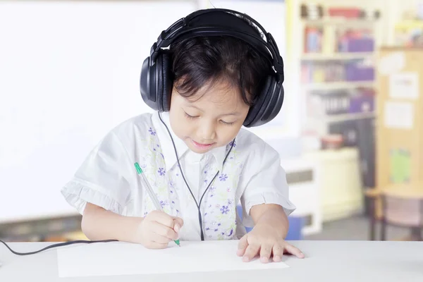 Primary school student studying in class with headset — Stok fotoğraf