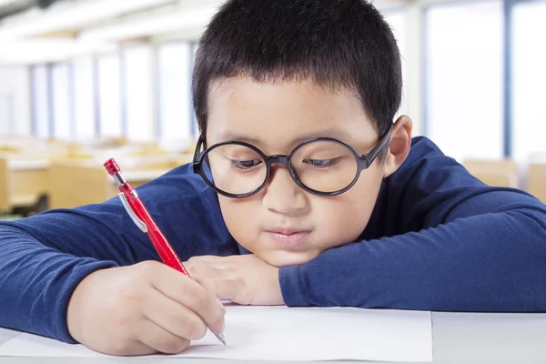 Un élève du primaire écrit sur le papier — Photo