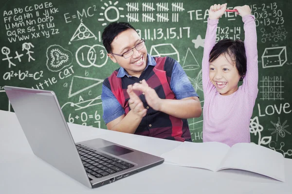 Successful little girl raising hands in the class — 图库照片